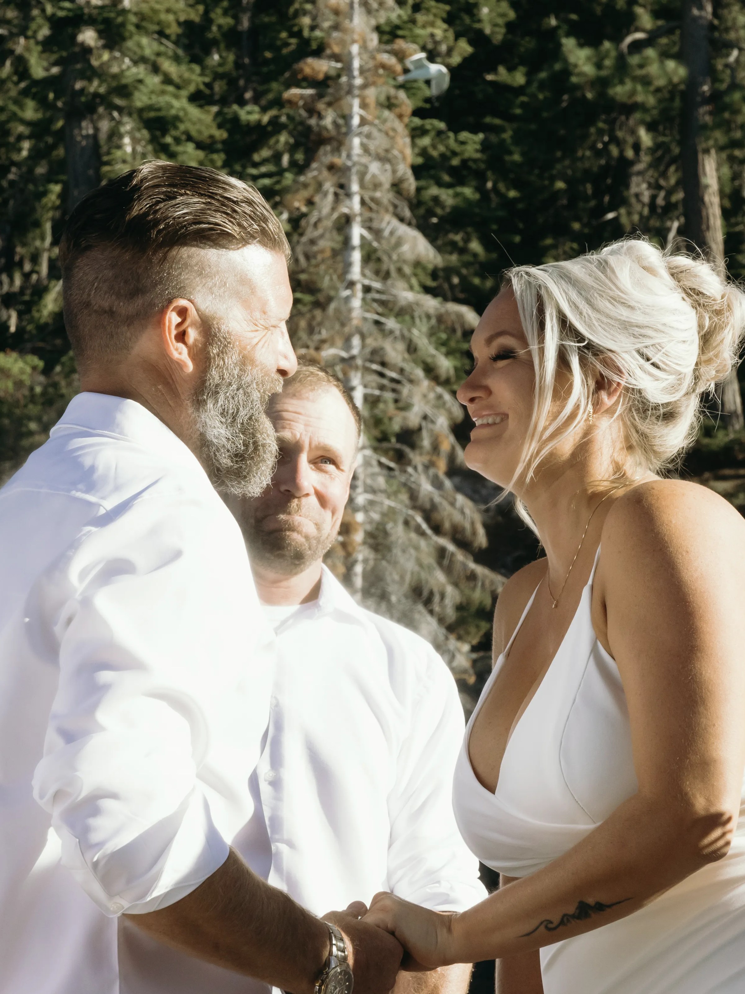 a man and a woman standing next to a forest