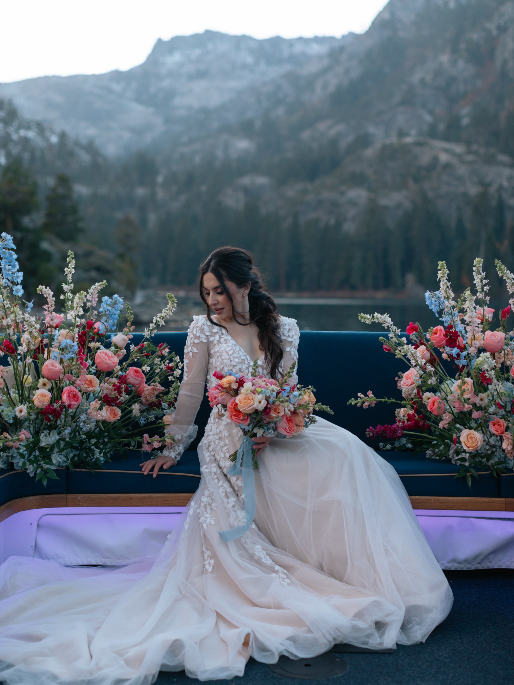 a woman in a pink flower is standing in front of a mountain